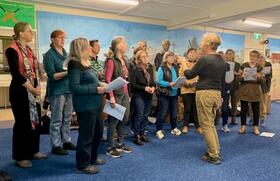 Rachel Hore conducys a cappella song for museum volunteers